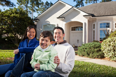 Happy family in front of house with a home warrranty.